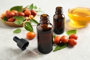 Glass bottle with jojoba oil and seeds