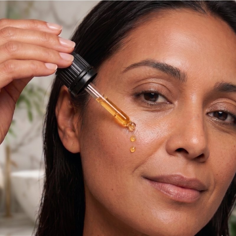 Woman applying Scenturie Super Boost Bakuchiol Serum to her face.