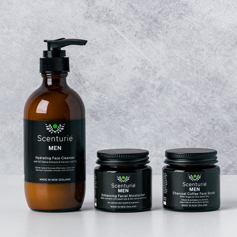 Scenturie's award-winning Men's natural skincare range featuring the Hydrating Face Cleanser, Enhancing Facial Moisturiser, and Charcoal Coffee Face Scrub in amber glass.