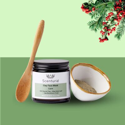 Scenturie Clay Face Mask Gift Set set on festive green background with Christmas mistletoe