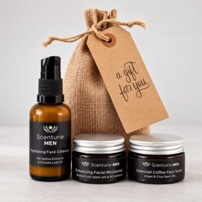 Men's natural travel skincare set arranged in front of an eco-friendly reusable drawstring grooming bag and gift tag.