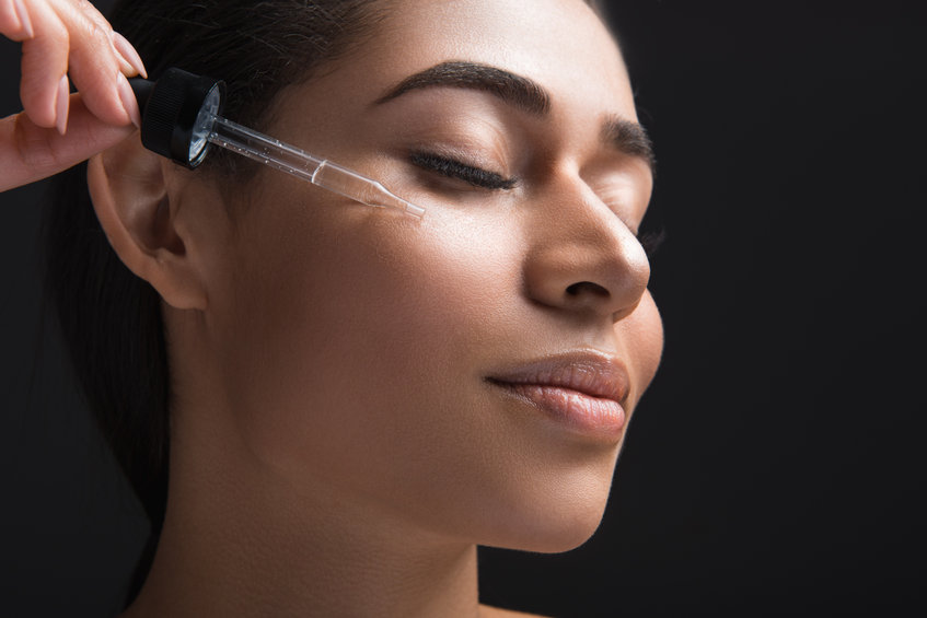 woman applying Scenturie bakuchiol serum