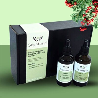 Scenturie's Radiant Glow Body Oil Gift Set, styled with festive green Christmas background with mistletoe.