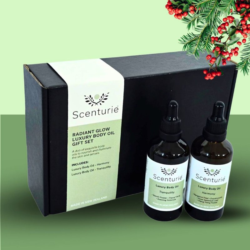 Scenturie's Radiant Glow Body Oil Gift Set, styled with festive green Christmas background with mistletoe.