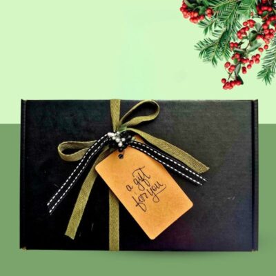 A black premium eco-friendly Scenturie gift box ready to be filled with natural skincare products, styled with festive Christmas background and mistletoe.