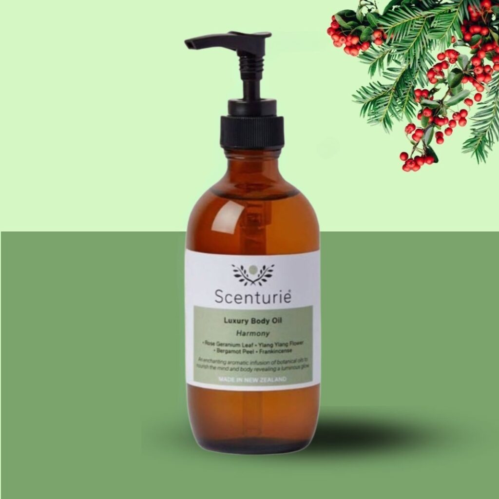 Scenturie Luxury Body Oil in an amber glass bottle, set against a festive green background with elegant mistletoe, perfect for a Christmas gift.