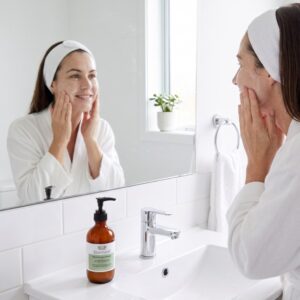 woman applying Scenturie Natural Creamy Cleanser to her face